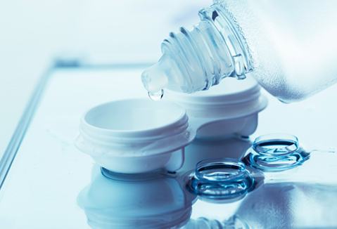 Bottle with contact  lens solution and case on table